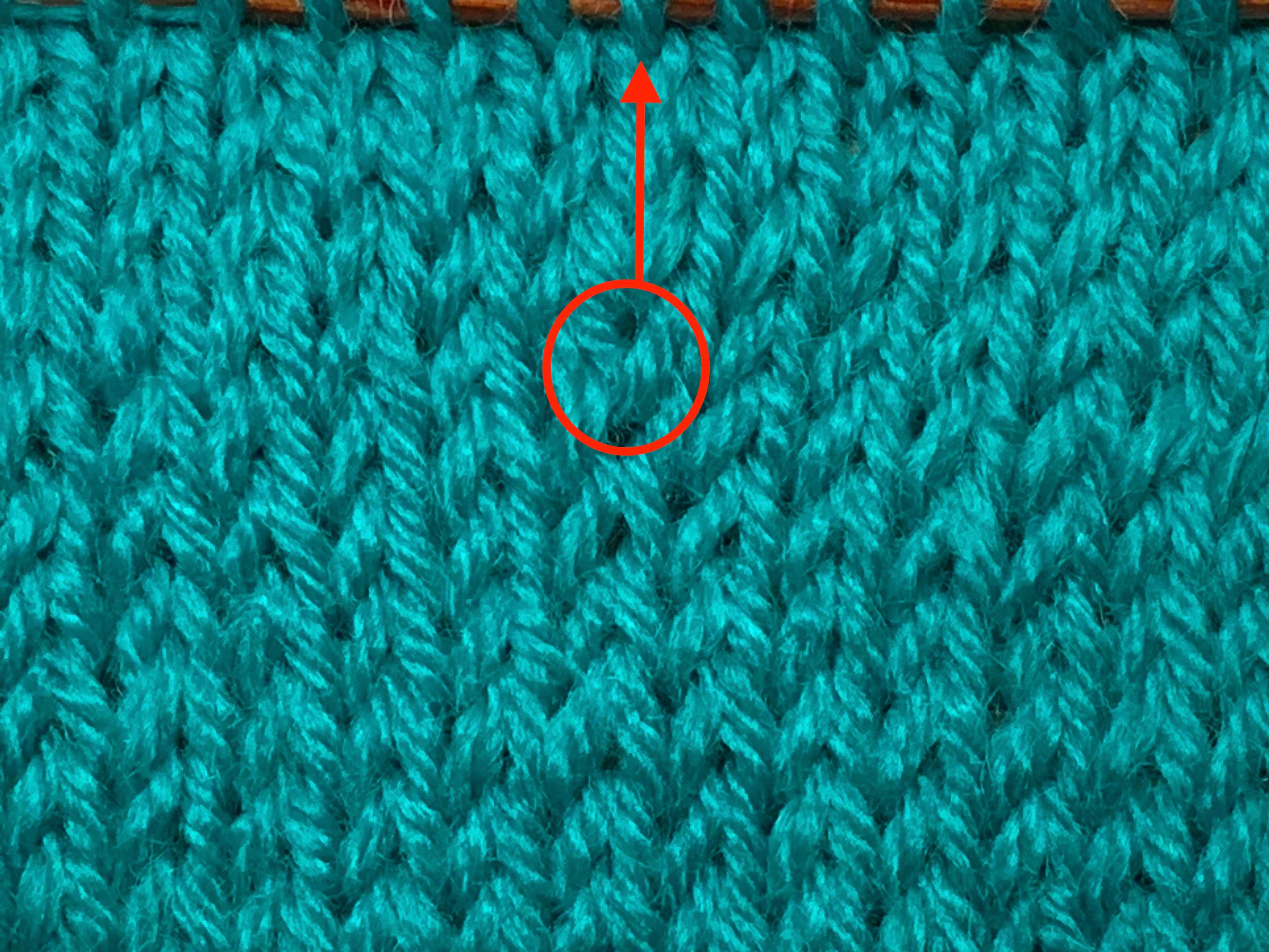 Close-up of a M1R circled in red. The red arrow indicates the new column of stitches. If you look closely, you can see that the stitch leans to the right.