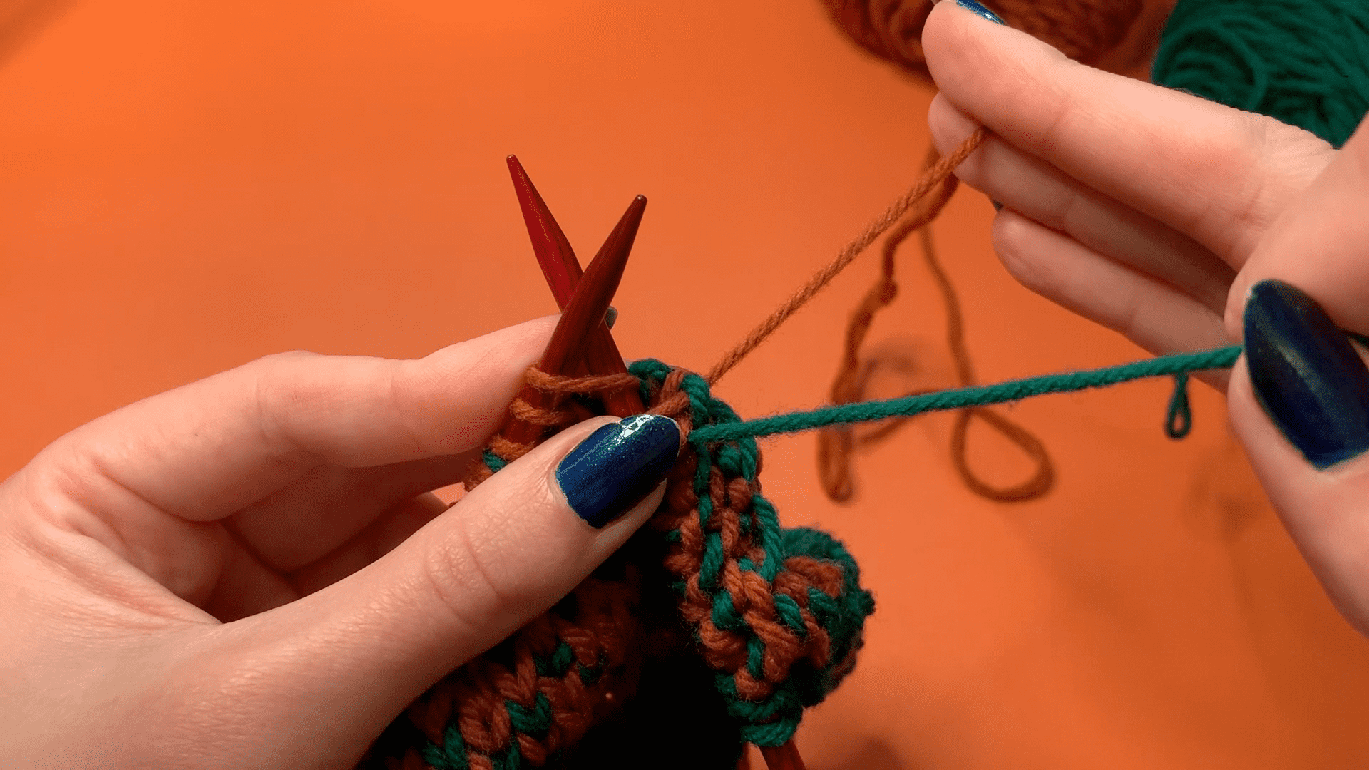 In this photo, the green yarn is the background color and so is crossed over top of the orange.