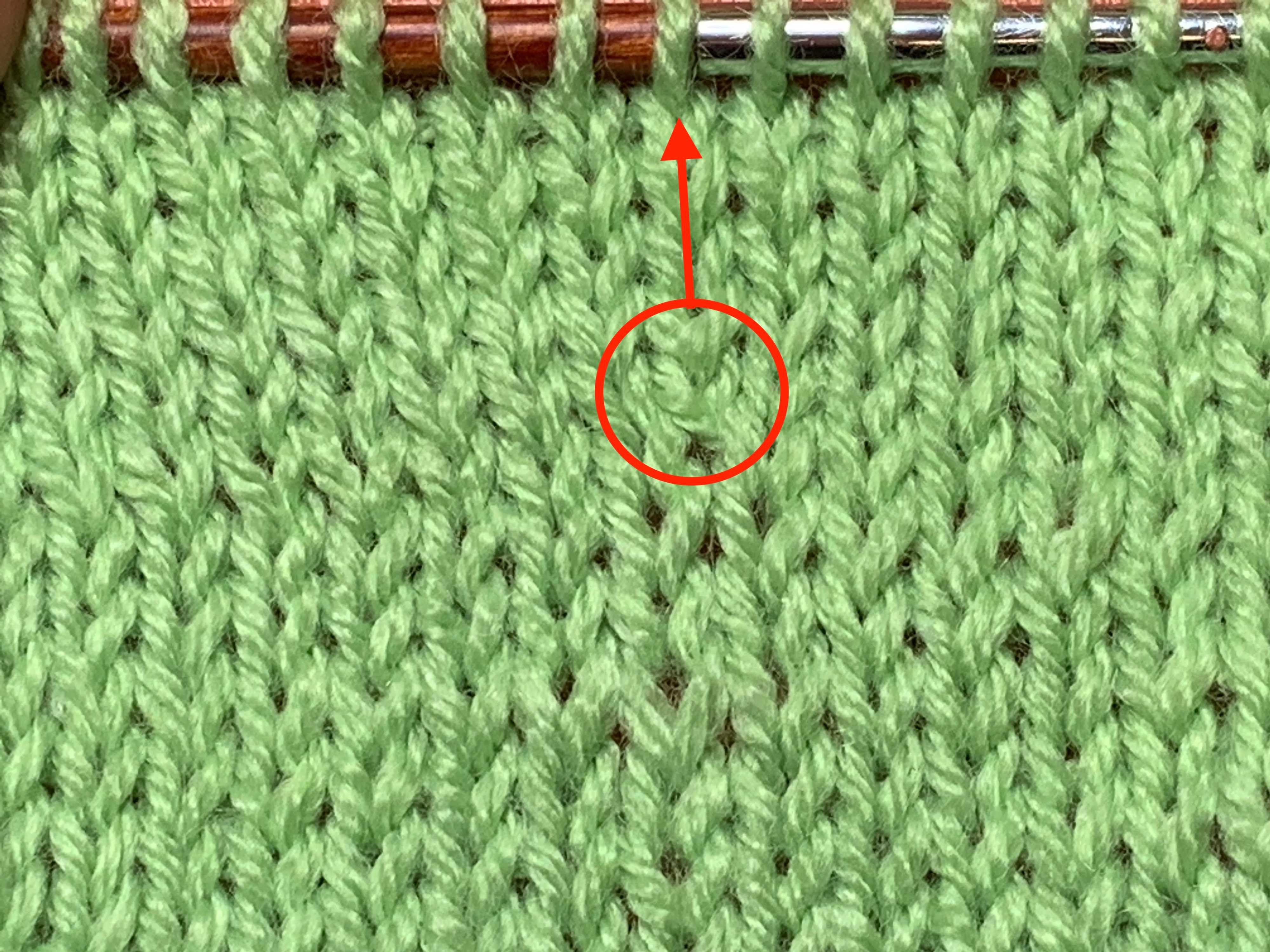 Close-up of a M1L circled in red. The red arrow indicates the new column of stitches. If you look closely, you can see that the stitch leans to the left.