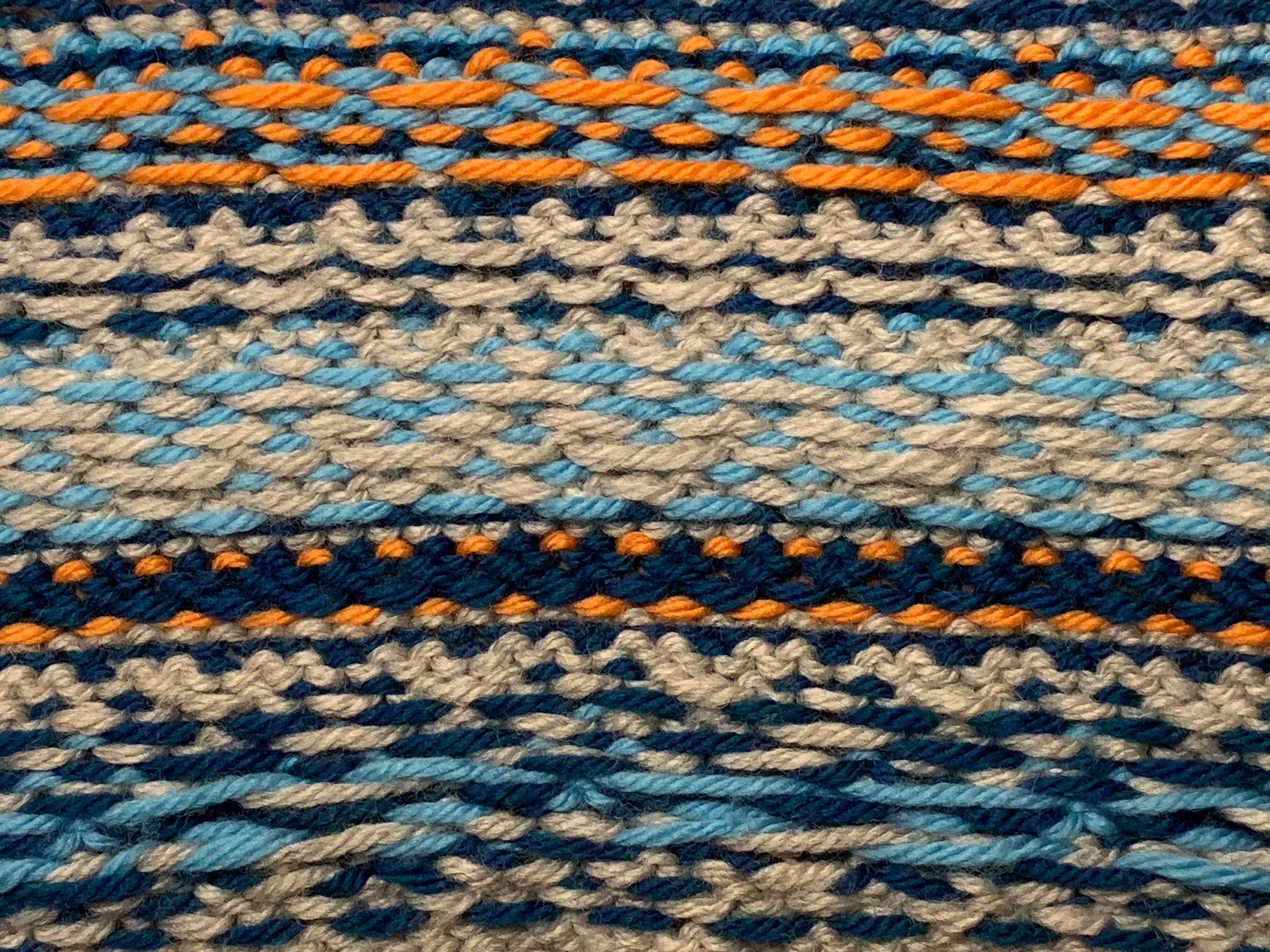 The wrong side of a stranded knitting piece, characterized by floats. Well tensioned floats are neither loose nor pulled taught when the garment is laid flat.